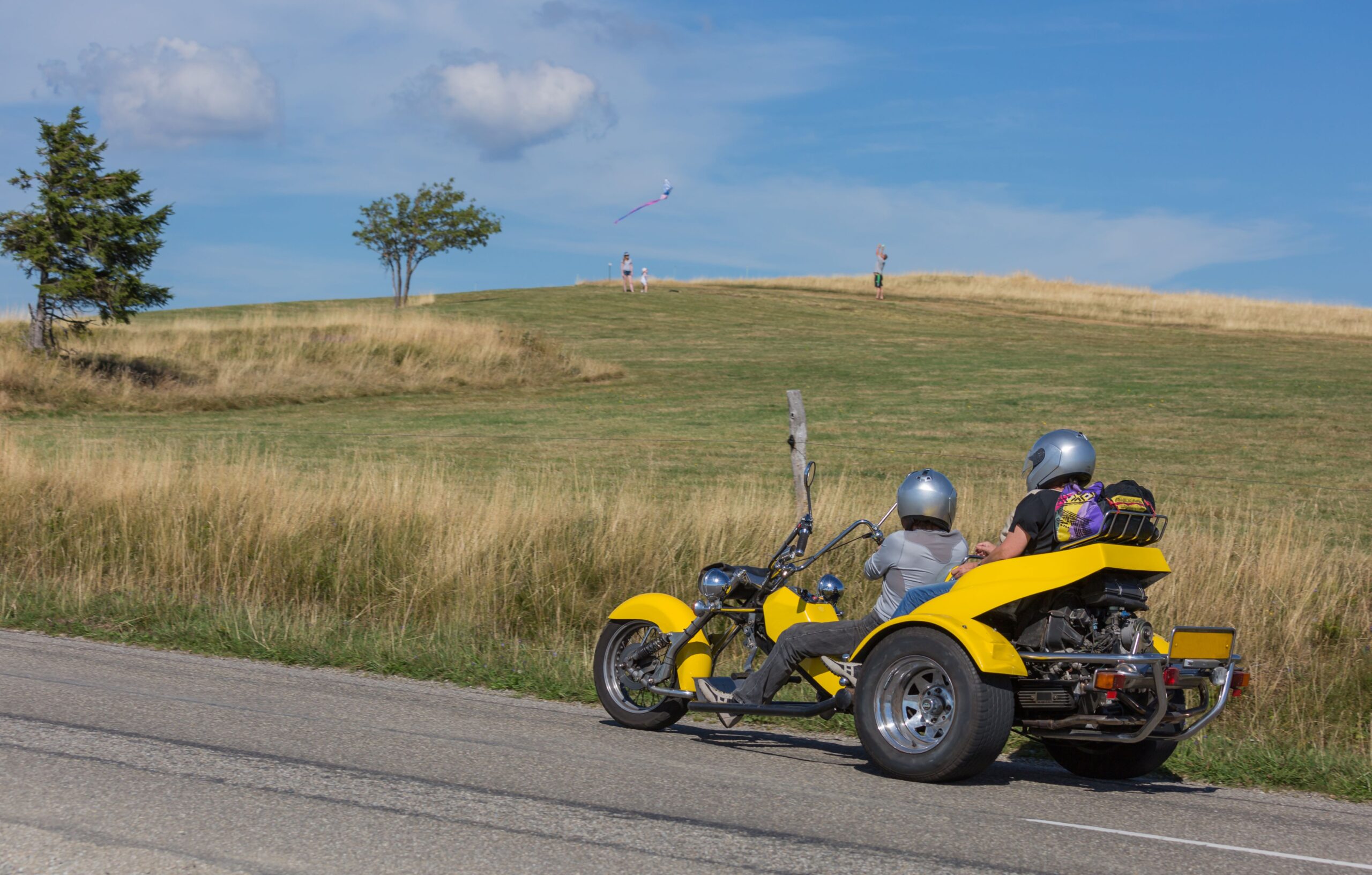 Eine Familie auf einem Trike in idyllischer Landschaft