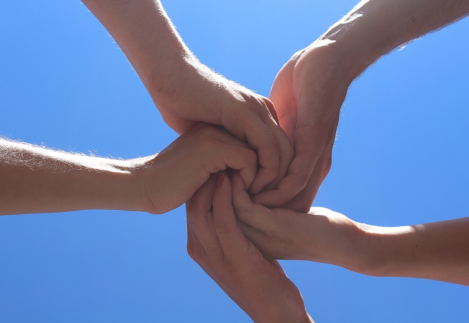 Mehrere Hände halten sich gegenseitig fest | Geschenk zur Geburt