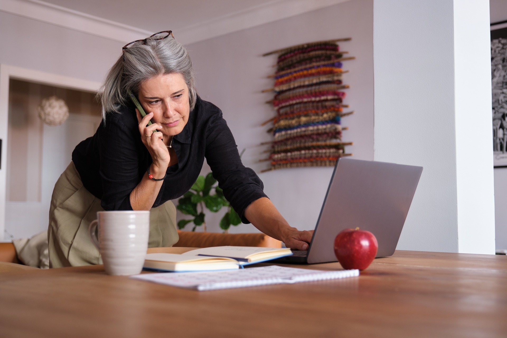 Aeltere Frau arbeitet am Laptop und telefoniert | Wasserspender für zuhause